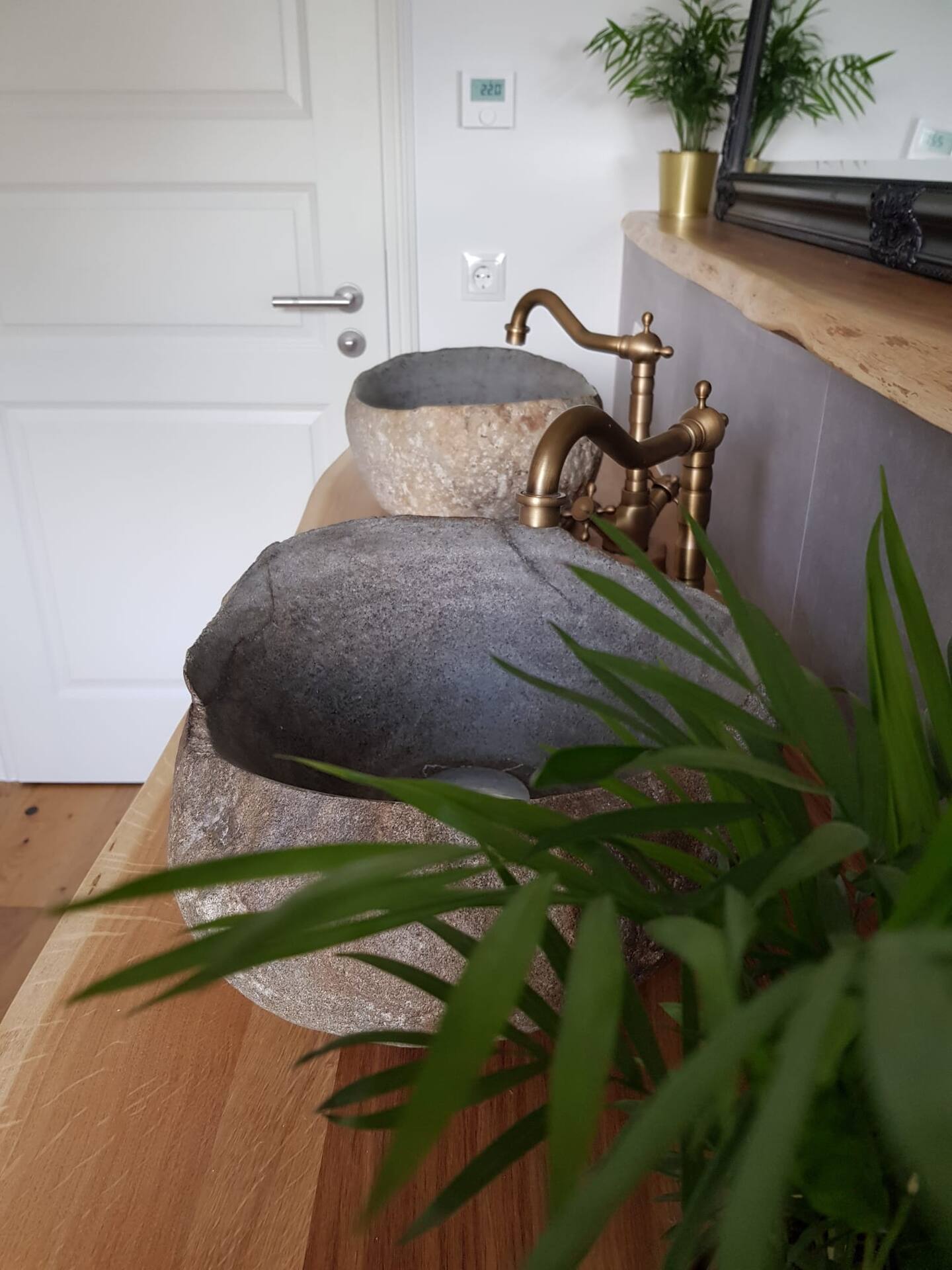 Badezimmer - Ausstattung/Details: Flusssteinwaschbecken mit antiken Armaturen auf einem Echtholzwaschtisch.